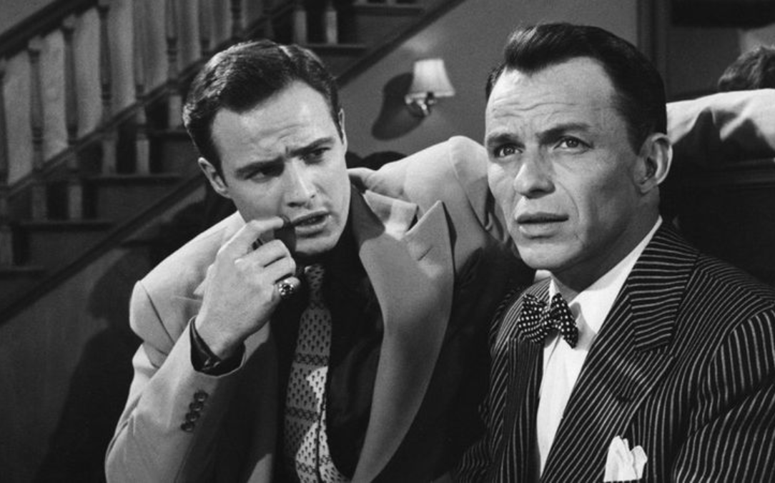 “Frank Sinatra and Marlon Brando apparently had a bit of a feud on the set of Guys and Dolls (1955), as Sinatra had wanted the lead. Brando asked Sinatra for help with some of the musical numbers, and Sinatra brushed him off saying that he "didn't go for that Method". In one scene that had Sinatra eating cheesecake (which he hated) while Brando talked, Brando would purposely do the scene perfectly and then mess up the last line, so they would have to re-do the scene, and Sinatra would have to have another slice of cheesecake.”